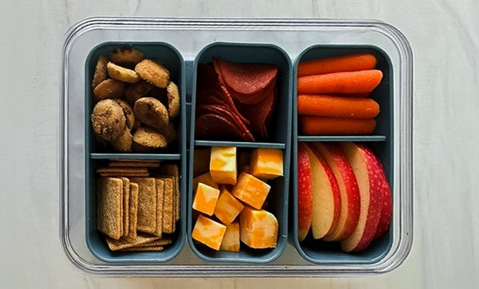Lunchable Snackle box with whole grain crackers, pepperonis, cheese cubes, carrots, apples, and mini cookies.