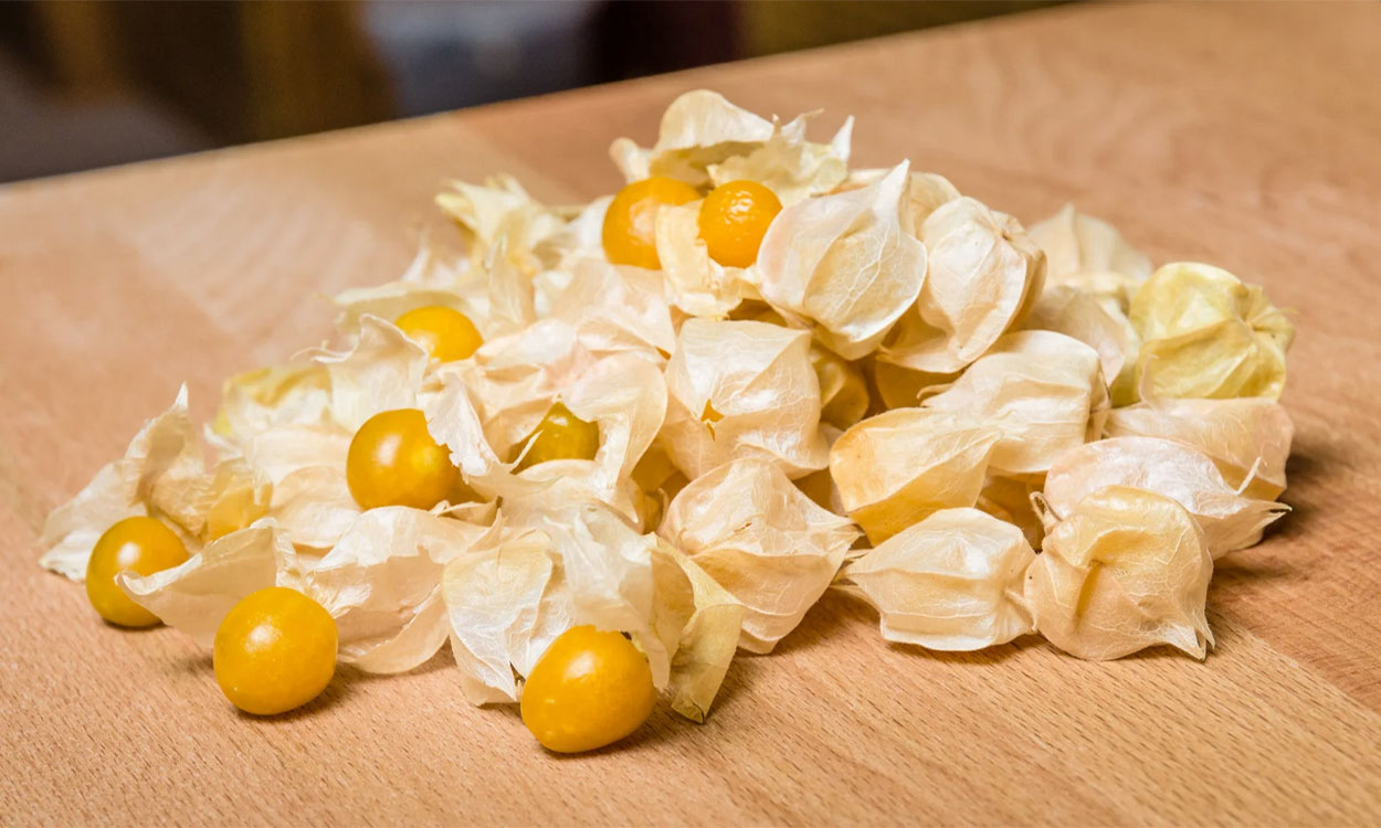 Yellow tomatillos on a cutting board.