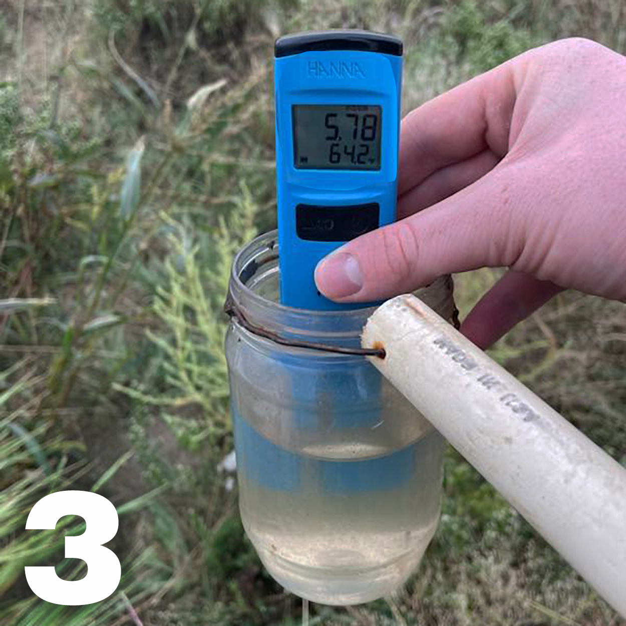 TDS meter immersed in a water sample.