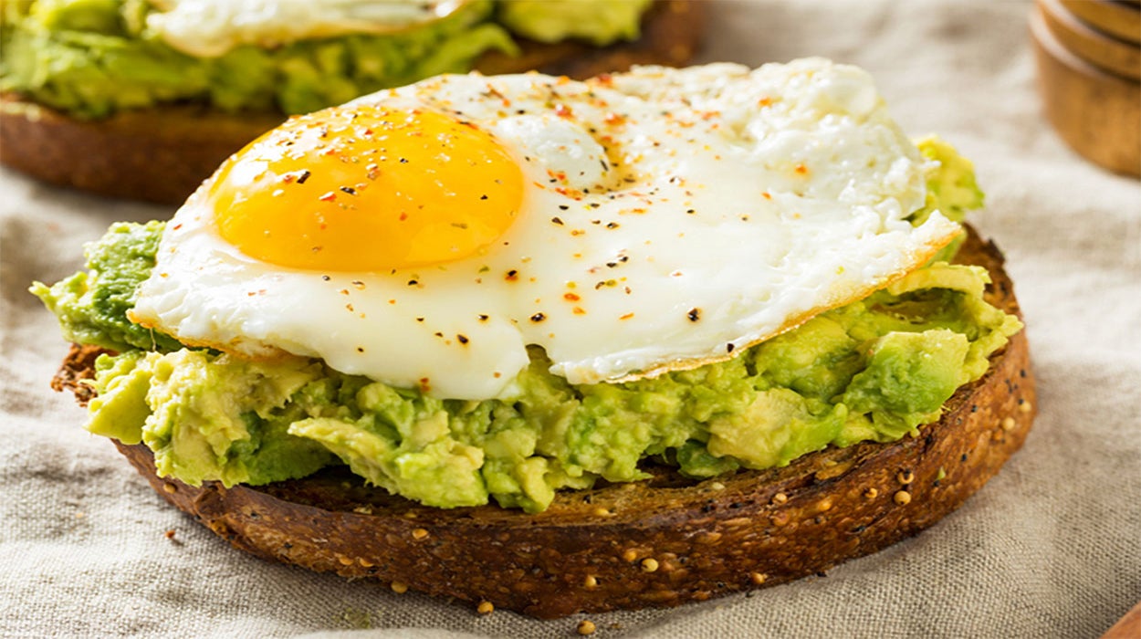 Fried egg on top of a piece of avocado toast.