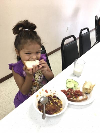 a young girl eating lunch