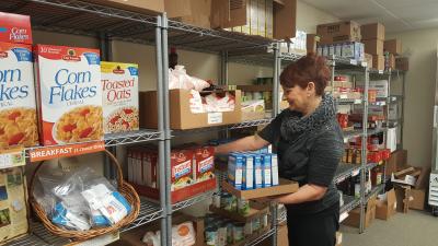 woman stocking shelves in a food pantry