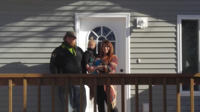 Alisha and Jordon Frost in front of their house.