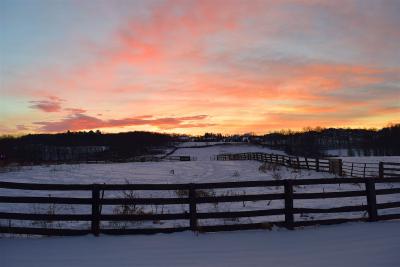 Sun rising over a ranch during winter.