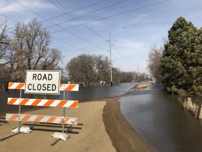 road closed sign in front of a flooded road