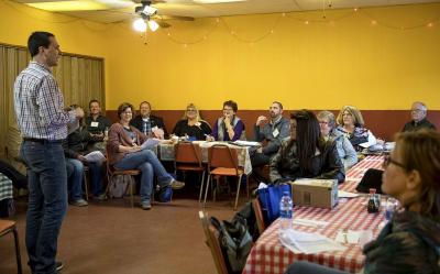 A young man leading a breakout presentation to conference attendees inside a local restaurant.
