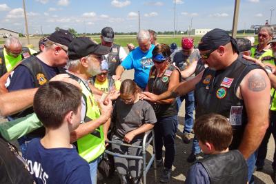 Jackie Rhode and members of the Christian Motorcyclist Association huddling for a group prayer.