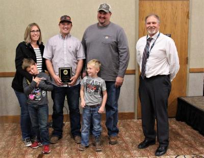 several adults and children standing together and accepting an award
