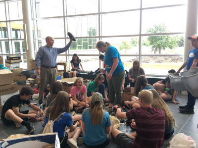 a group of adults and children sorting shoes