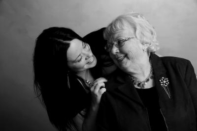 older mother and adult daughter smiling at each other
