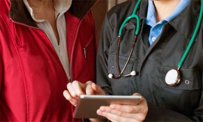 Veterinarian and rancher reviewing testing information on a tablet.