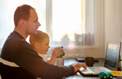 Father and son participating in a remote meeting at home.