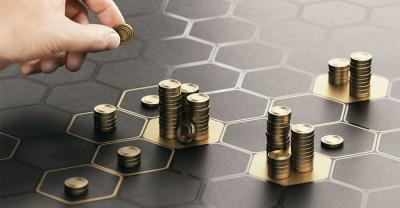 Hand stacking coins into small piles on a grid.