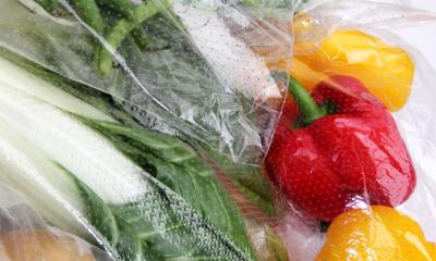 Variety of vegetables ready for storage in clear, perforated bags.