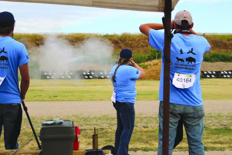 4-H, Shooting Sports, Muzzleloading gun, Adolescent girl shoting a muzzleloading gun while 2 adolescent males watch