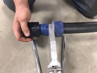 A hand displaying a welded pipe system joint.
