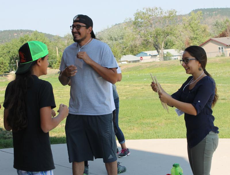 Group of youth playing guessing sticks.