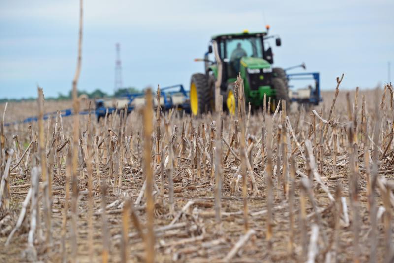 A green tractor planting seeds in a no-till field. Courtesy: United Soybean Board [CC BY 2.0] via Flickr