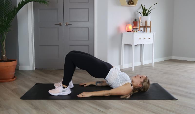 Young woman demonstrating the Bridge core exercise.