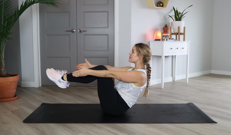 Young woman demonstrating the Superman Pull core exercise.