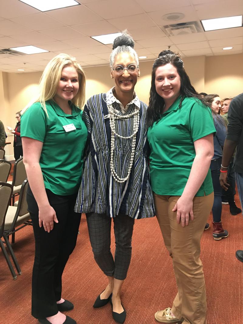 two women with green shirts standing next to another woman