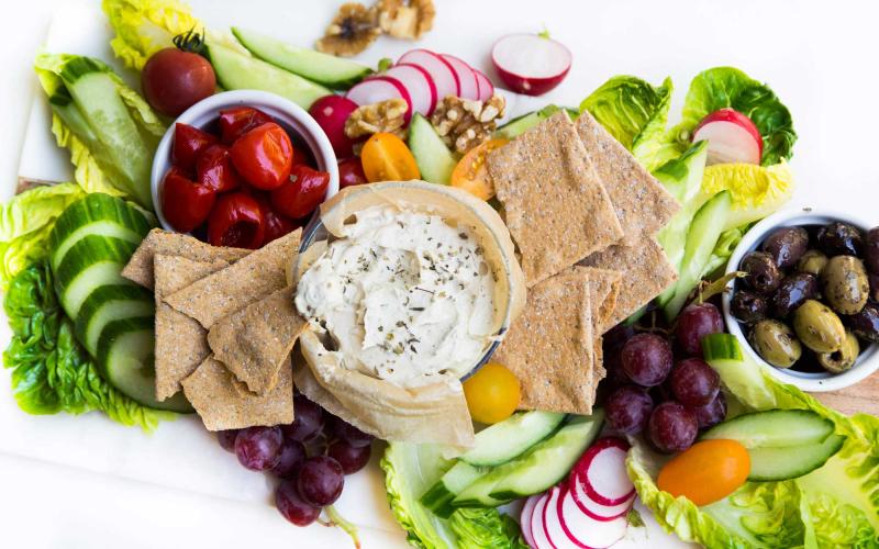 Veggie and dip platter surrounded by fresh vegetables.