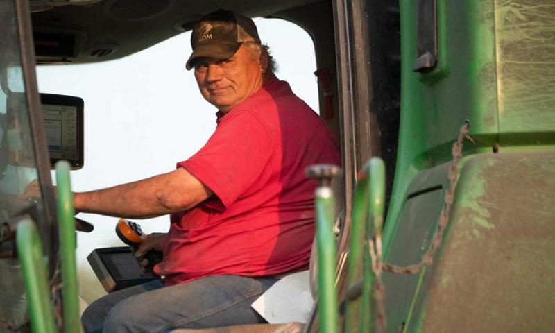 Farmer calibrating a yield monitor insde a combine cab.