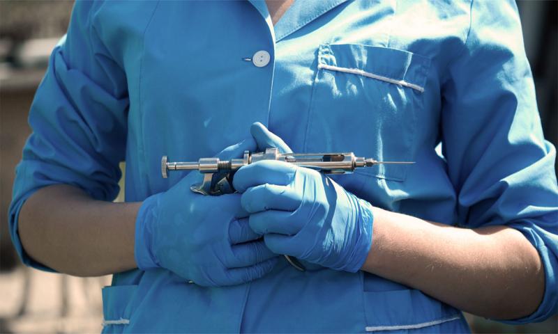 Veterinarian holding a syringe gun for animal vaccinations.