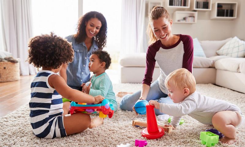 Parents playing with their children in a living room.