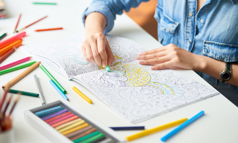 Adult female coloring in an adult coloring book.