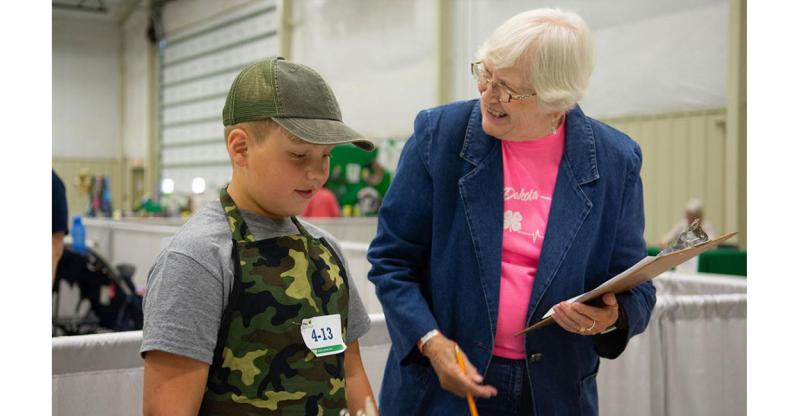 4-H volunteer talking to a 4-H youth.