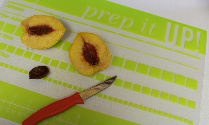 Boiled peach cut in half with the pit removed.