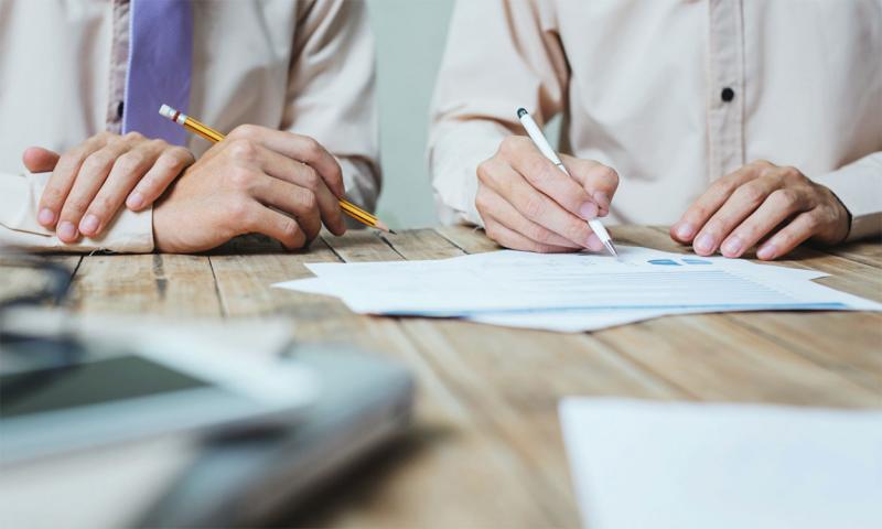 Two board members reviewing legal paperwork at a table.