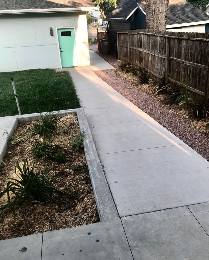 Rear, no-step entrance of a modern, adaptable home with a level walkway.