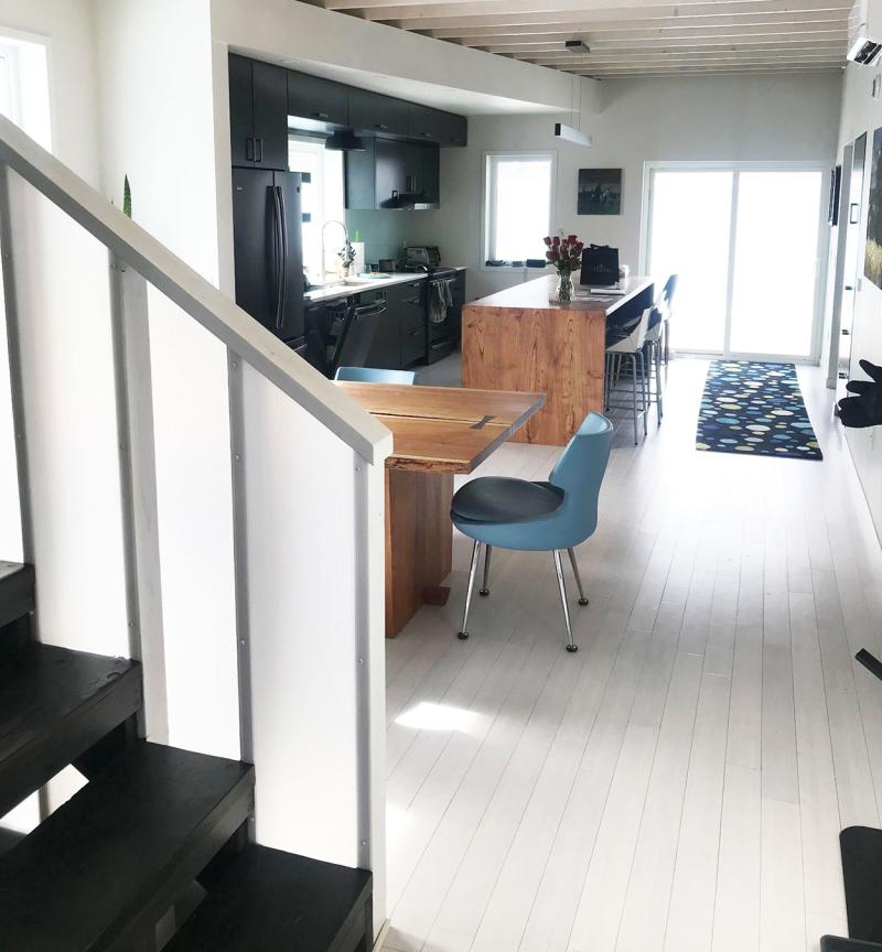 Modern, adaptable kitchen with ample space around essential features, including stairs and appliances.