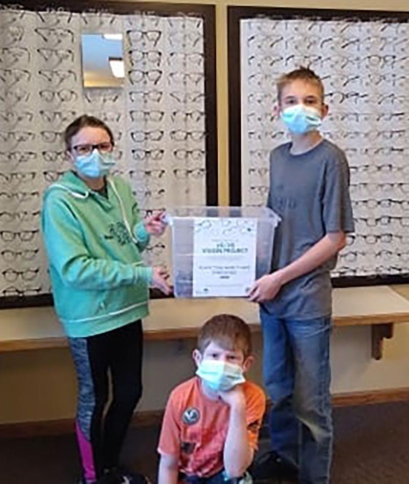Atty Eastman, Jonathan Burleson and Joshua Burleson collecting glasses at an eye clinic for the South Dakota 4-H "20/20 Vision" community service project.