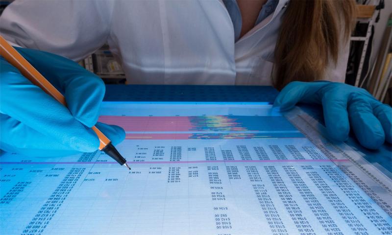 Young, female scientist analyzing genetic code in a laboratory.