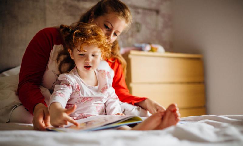 Mother reading a storybook to her child.