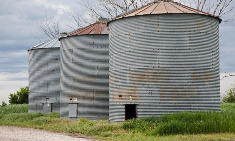 Three, rusted grain bins.