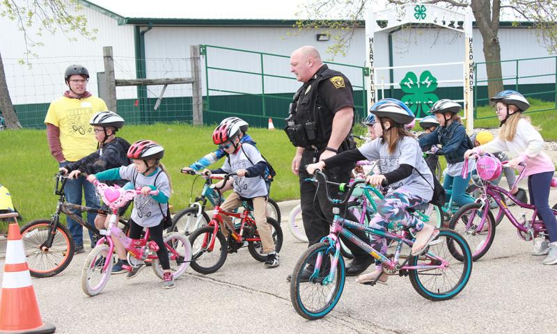 Group of youth riding bikes through a bike handling station.