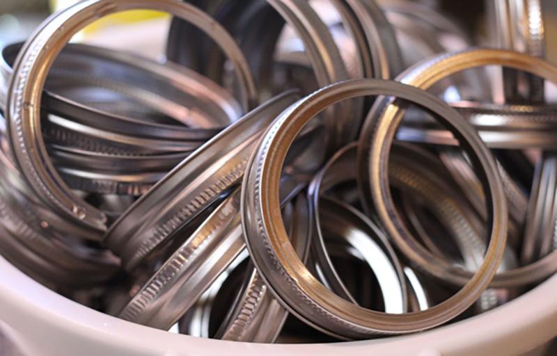Canning jar lids in a container.