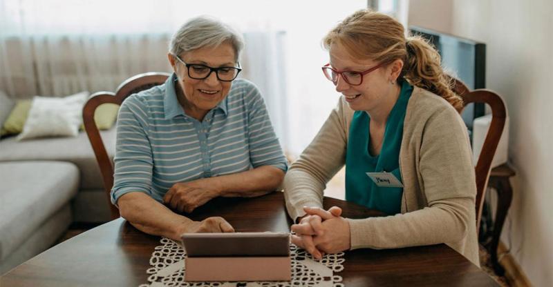 Home health care specialist visiting with an older female adult.