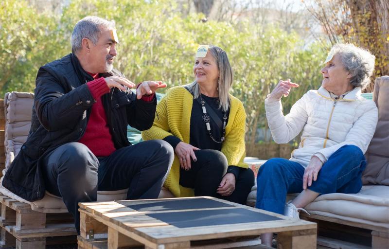 A group of older people sitting outside talking