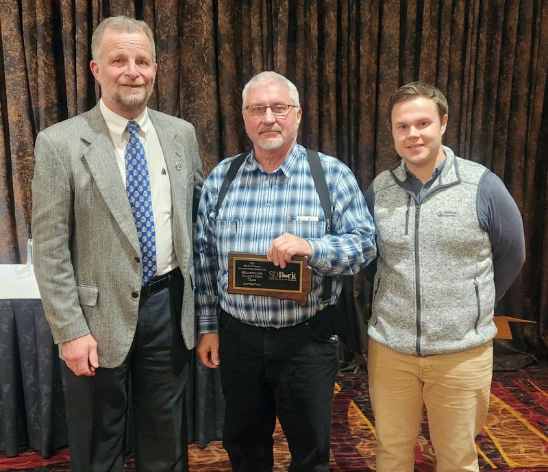 2022 Master Pork Producer Winners Three men stand in a row, and Steve Waldner stands in the center displaying the plaque he won from South Dakota Master Pork Producers