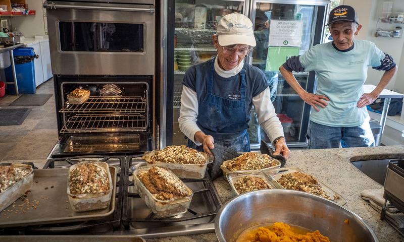 Two bakers producing baked goods in a licensed commercial kitchen.