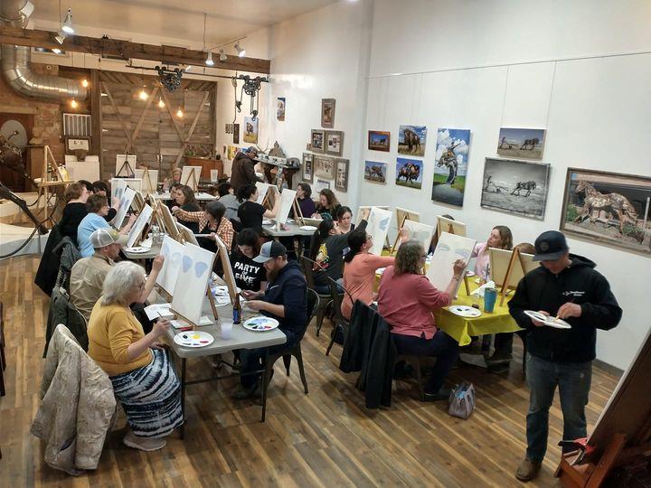 A picture of around a dozen local artists in Lemmon, South Dakota, posed in front of easels.