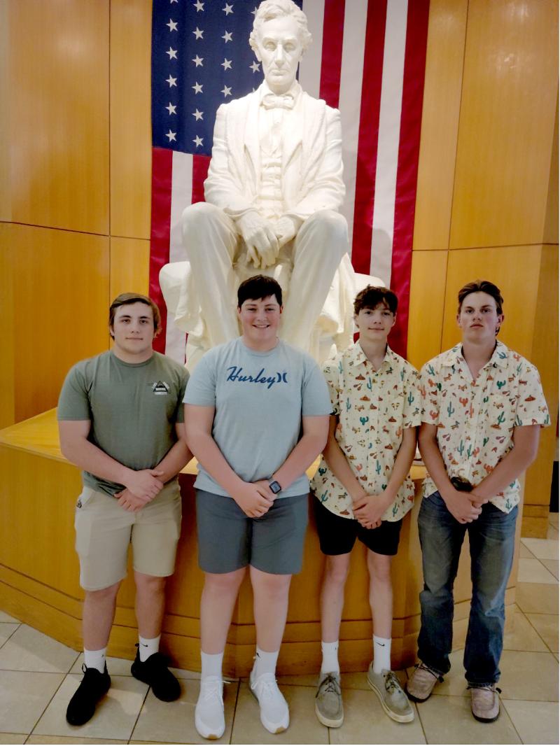 The McCook County 4-H Land Judging Team, Will Rotert, Joe Grady, Colton Stiefvater and Lane Deutsch, stand in front of a white statue of Abraham Lincoln