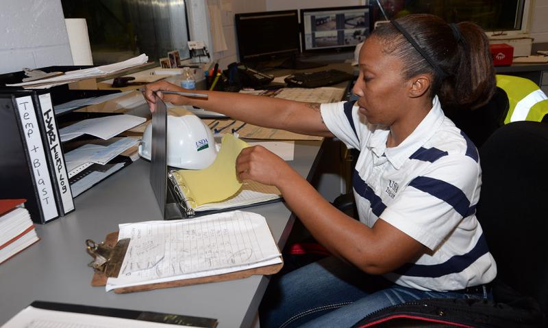 U.S. Department of Agriculture Food Safety Inspection Service inspector reviewing paperwork.