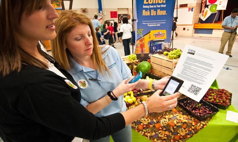 Vendor and inspector examining a letter of verification at indoor famers market.