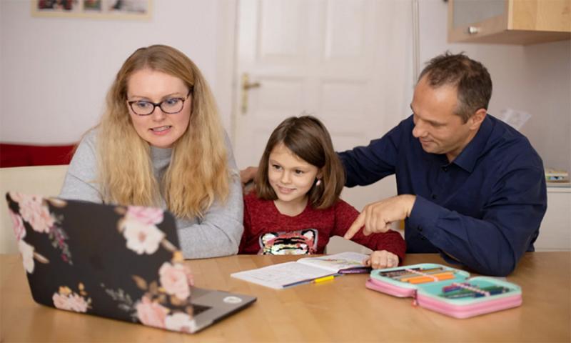 Parents helping their daughter prepare for school.